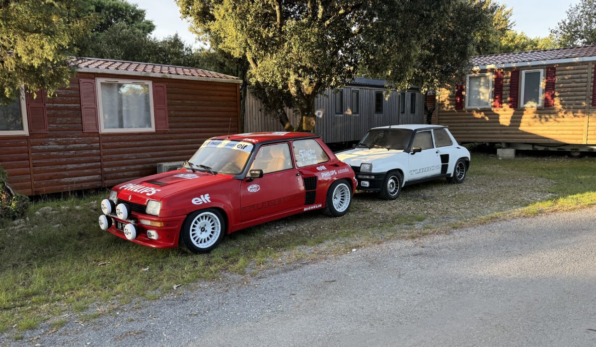 Renault 5 Turbo rouge avec livrée Philips et R5 Turbo blanche stationnées devant des mobil-homes au camping Capfun d'Imbours.